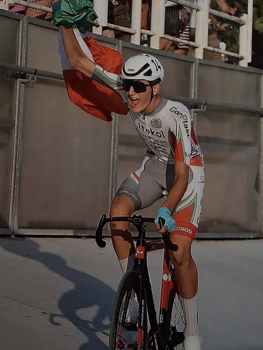 Atleta in maglia Litokol alza la bandiera italiana al traguardo