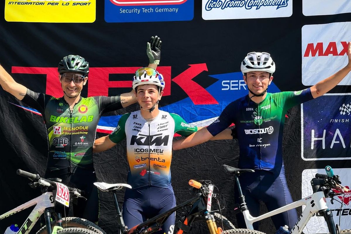 Podio di una gara di mountain bike, tre atleti a braccia alzate
